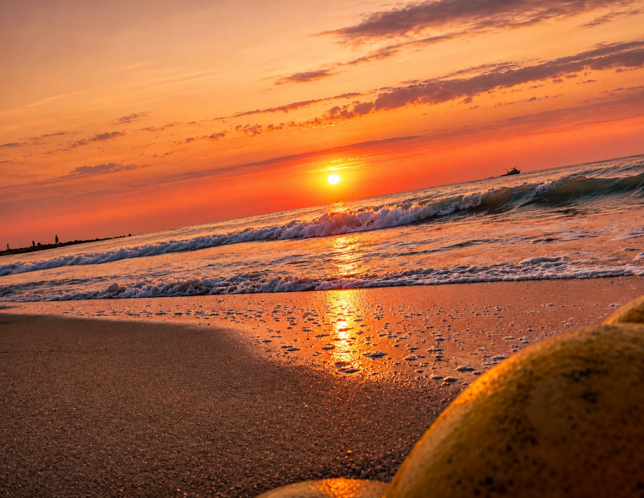 Orange beach sunset with waves and shoreline texture